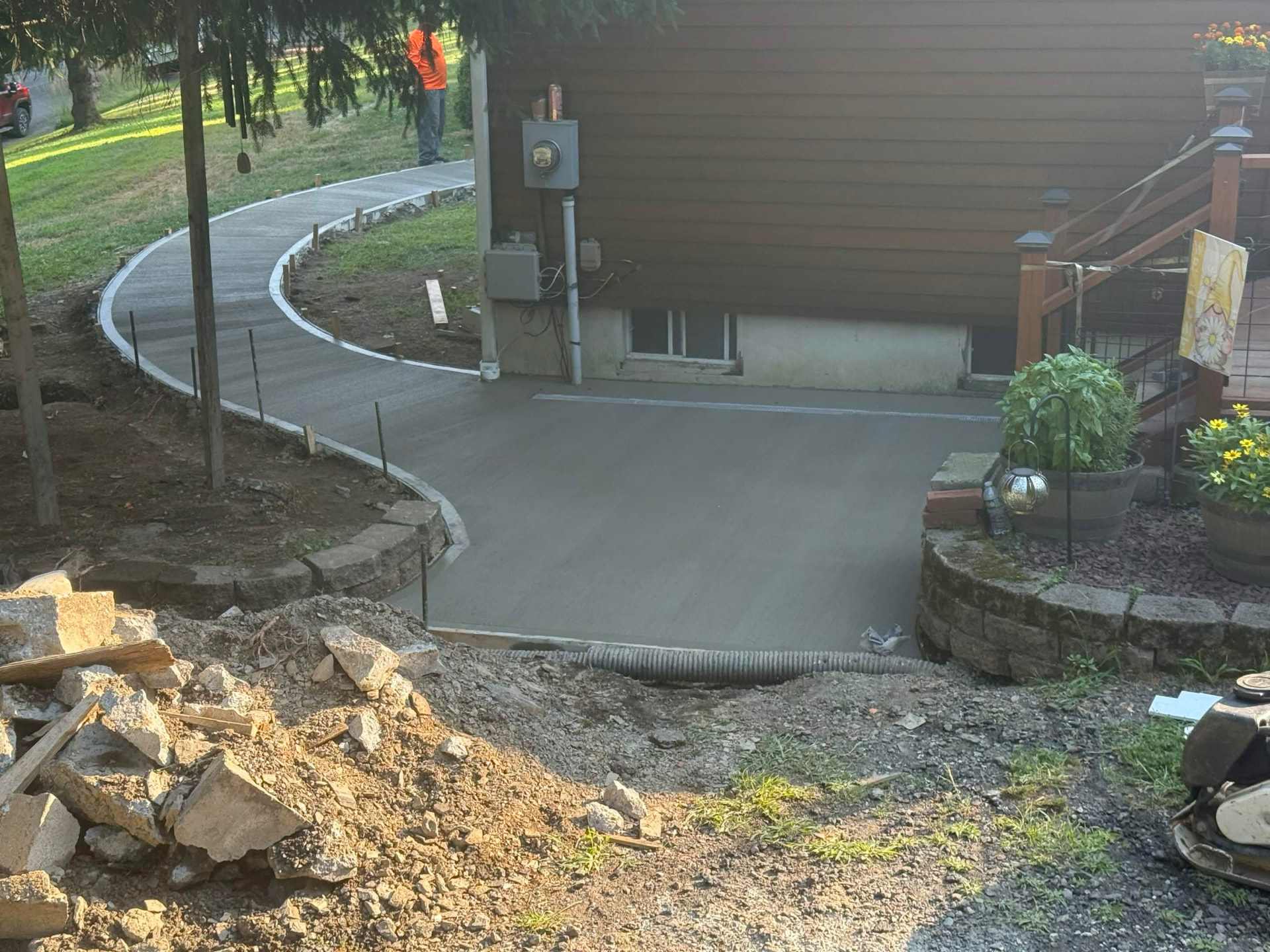 Curved concrete driveway apron poured beside a home