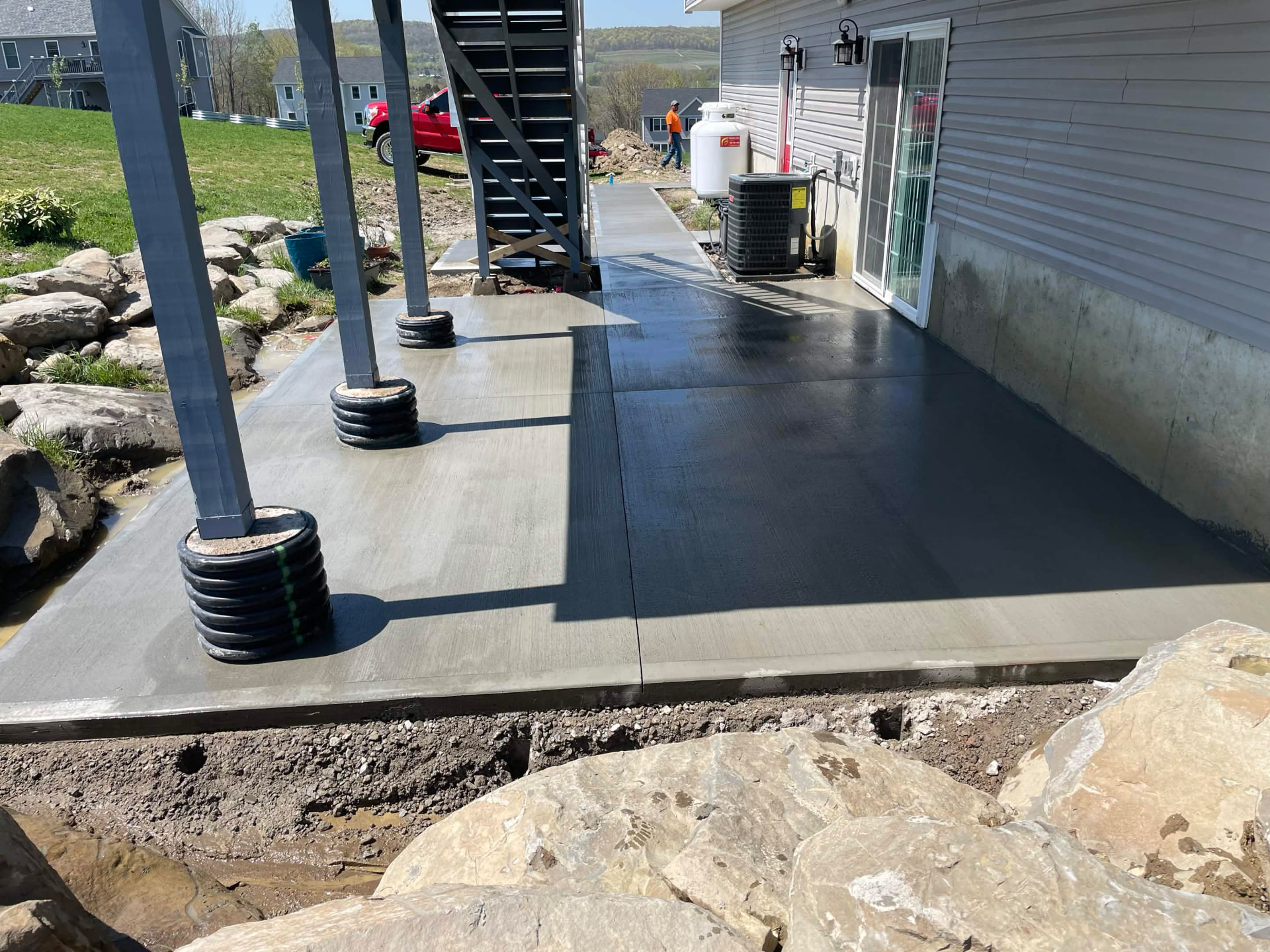 Smooth concrete patio completed under a raised deck