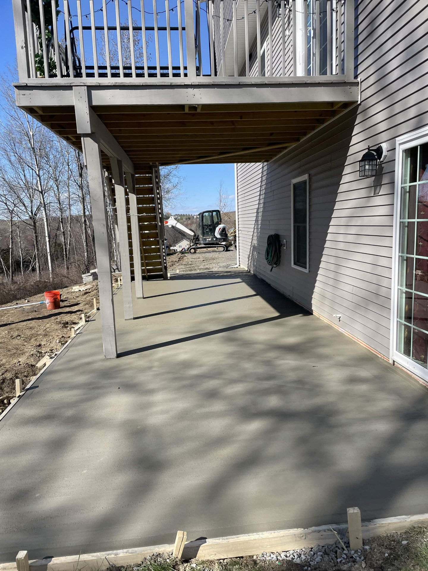 Concrete patio slab finished under a second-story deck