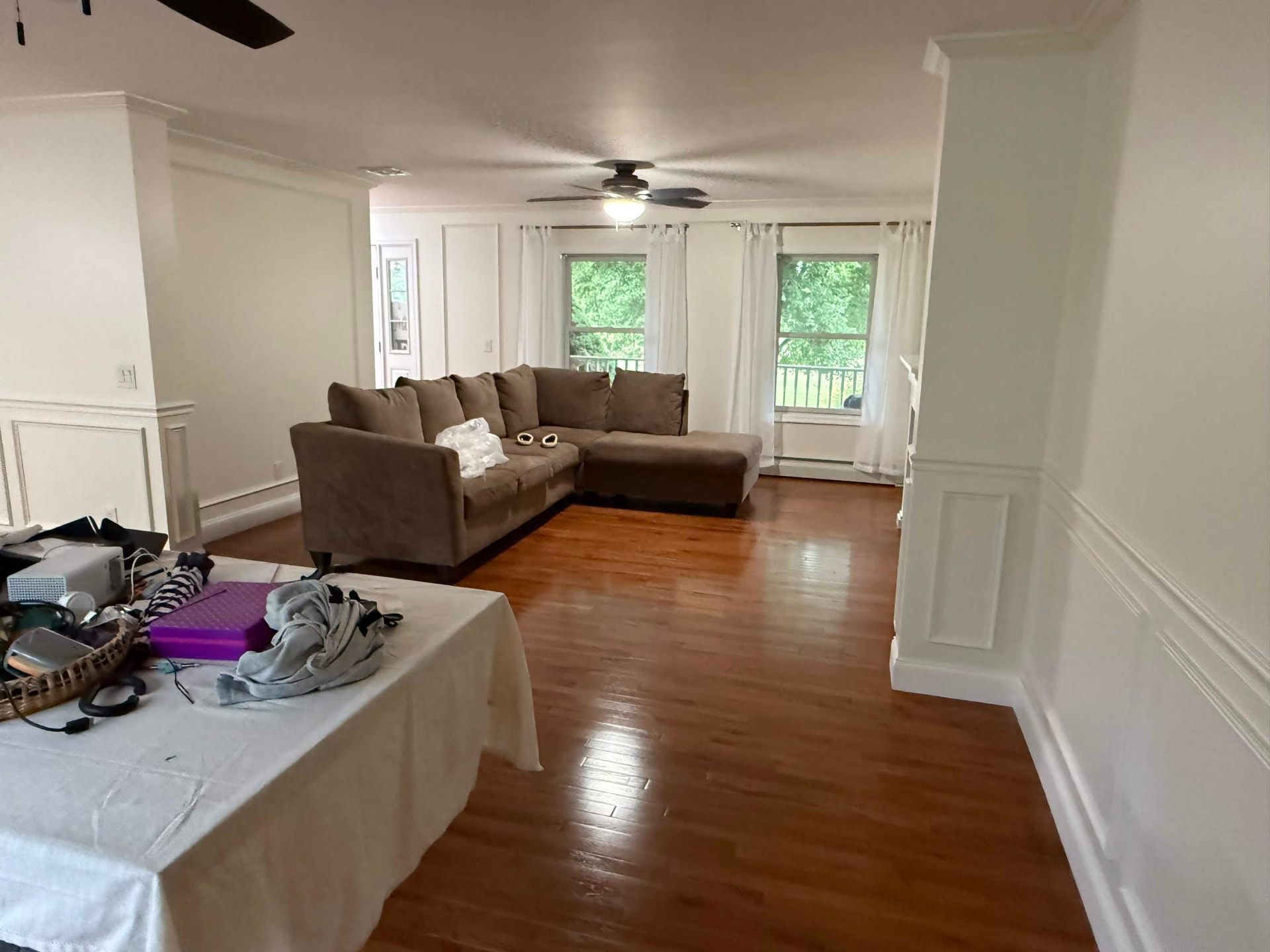 Completed living room with paneled walls and hardwood floors