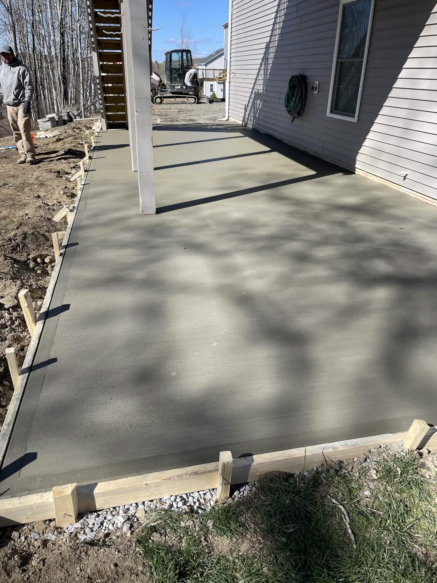 Cured concrete walkway slab running along the side of a home